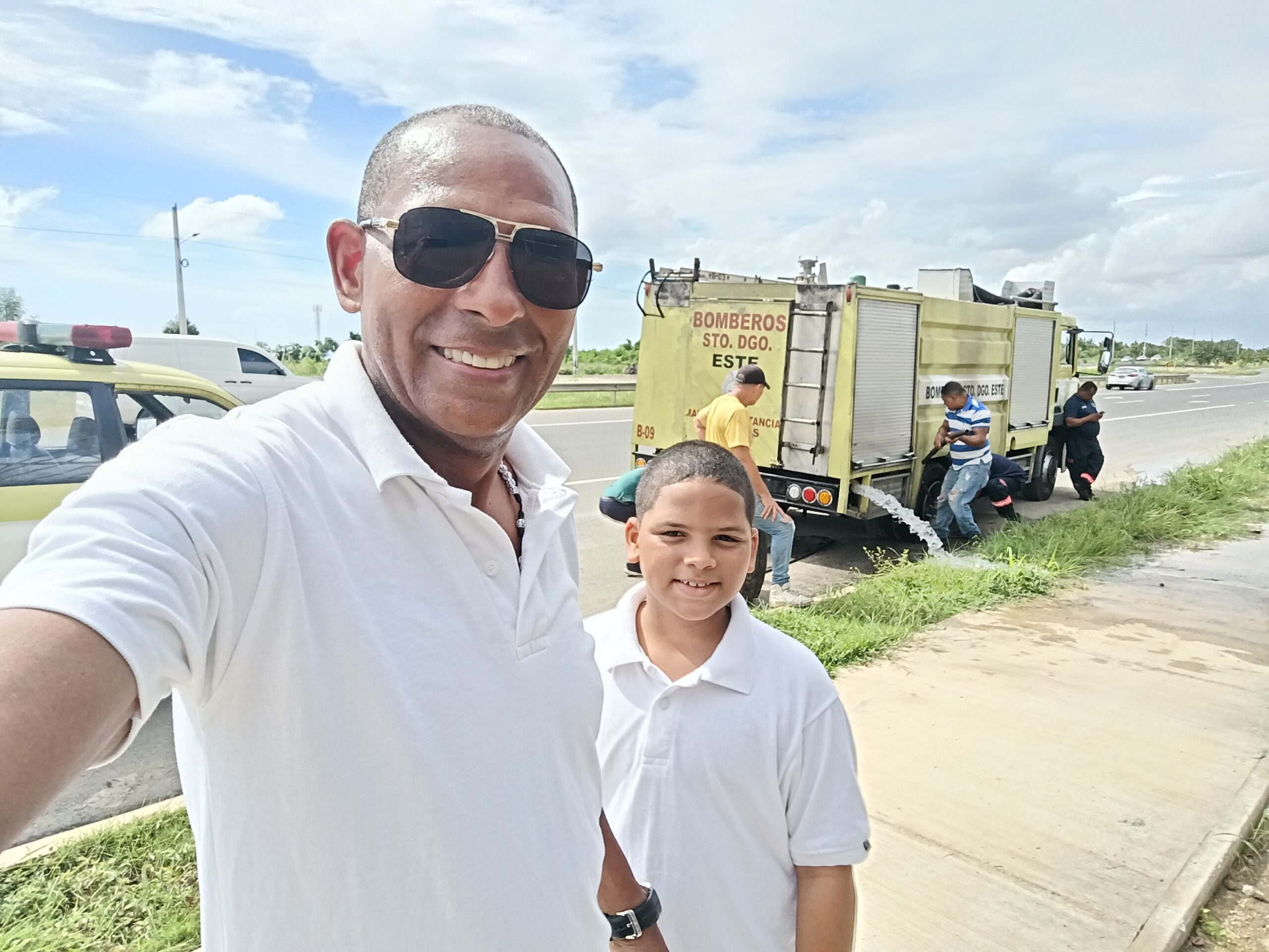 El periodista Primitivo Gil, junto a su hijo menor, auxilia a bomberos de Santo Domingo Este en un gesto ejemplar de solidaridad ciudadana